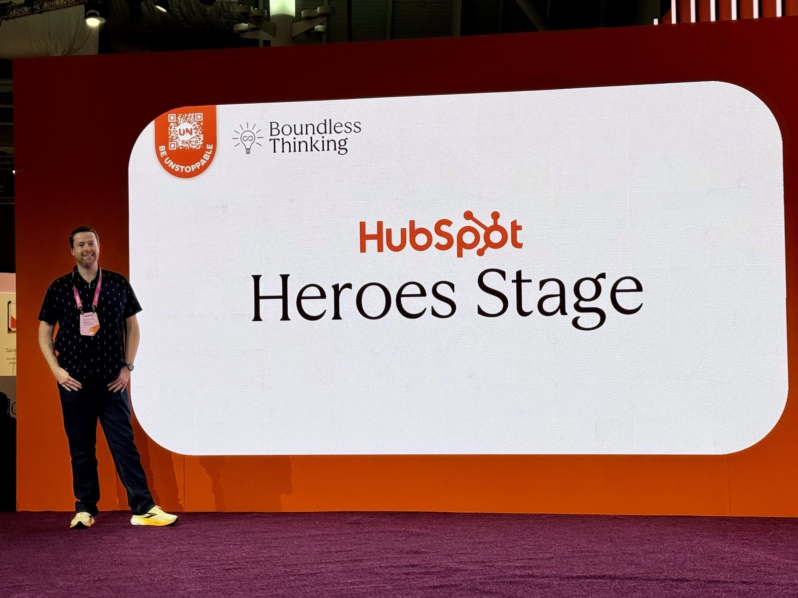 Matthew standing beside the HubSpot Heroes Stage screen at UNBOUND